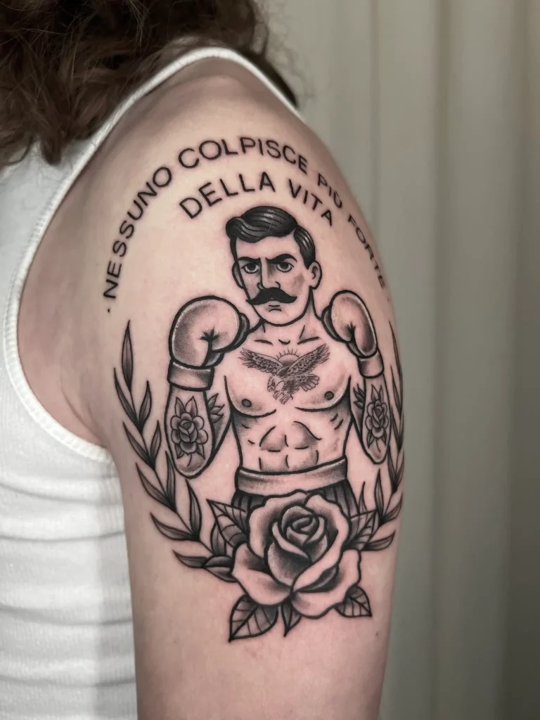Tattoo auf dem Oberarm, dass einen Mann mit Boxhandschuhen zeigt im Oldschool Stil