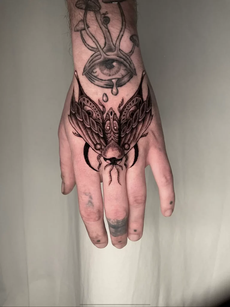 Tattoo einer Motte auf dem Handrücken
